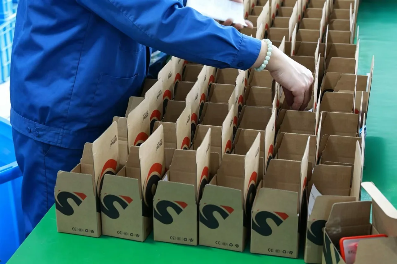 Operator packing switch products into divided paperboard boxes